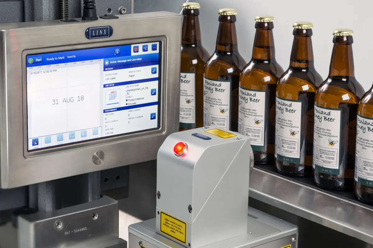 LINX CSL60 Laserbeschriftung von brauen Bierflaschen an der industriellen Getränke-Abfülllinie
