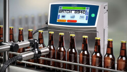 Brown glass bottles being labelled in a production line