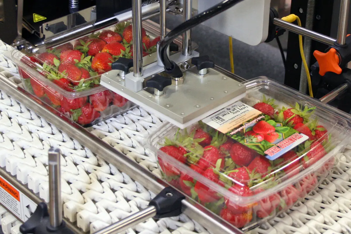 Labels being applied automatically to plastic clamshell packaging