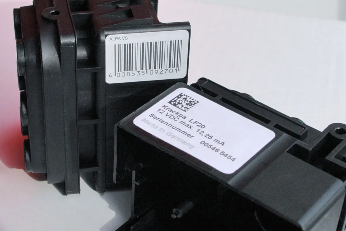 Plastic component with adhesive label applied to its side